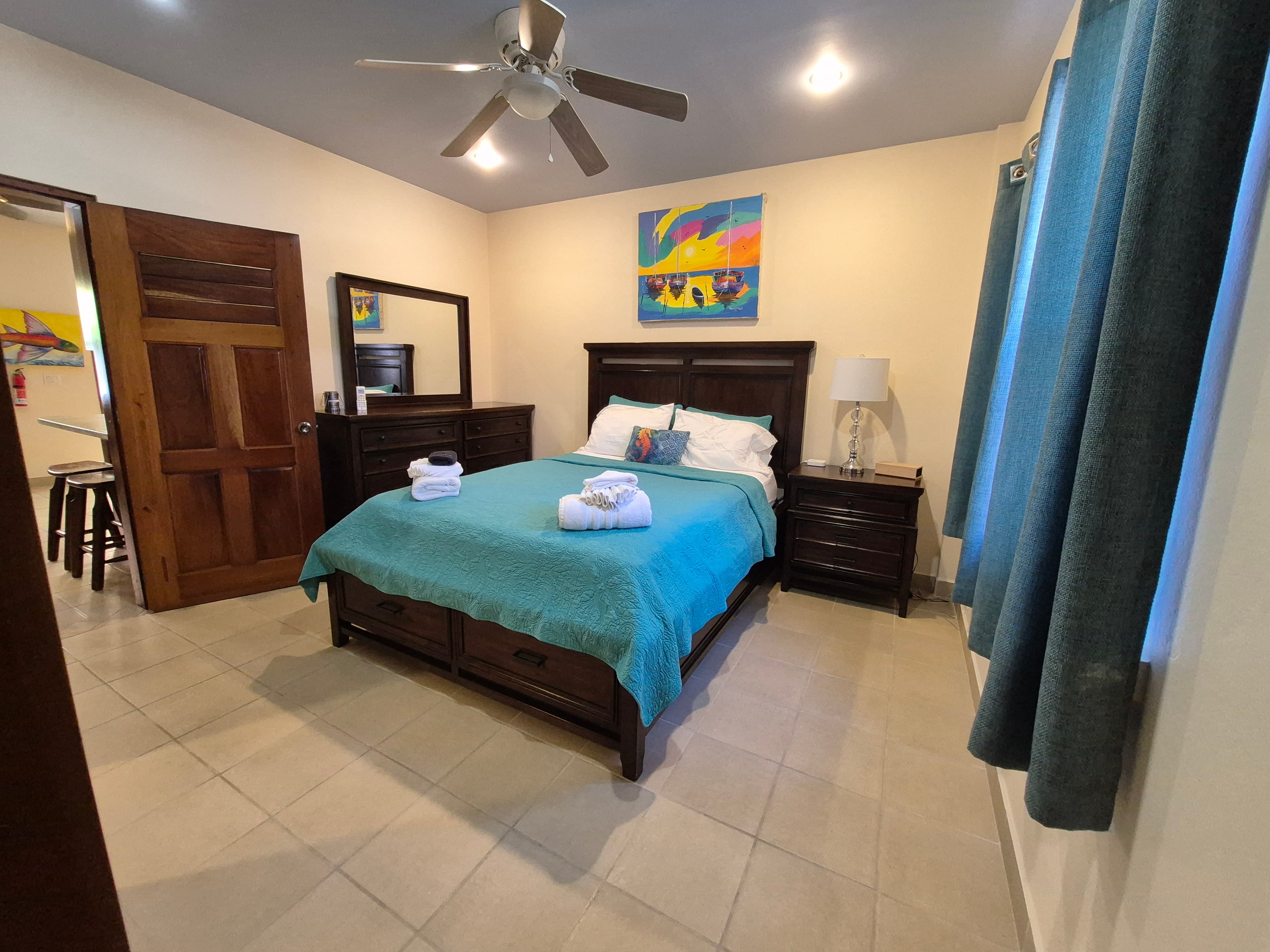 Bed with night stand to the right and a dress with a mirror to the left