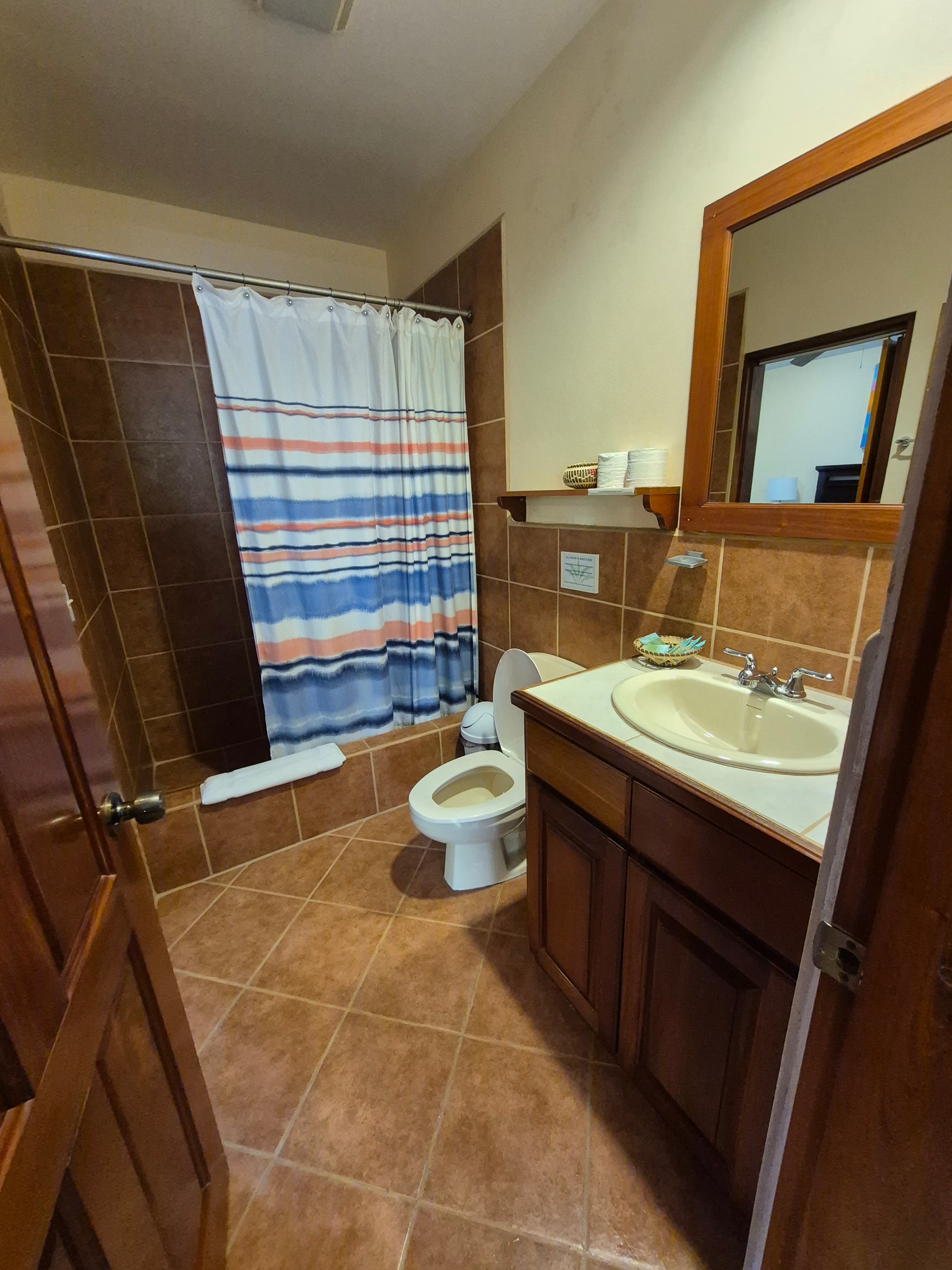 Standard bathroom with a shower, toilet, and sink